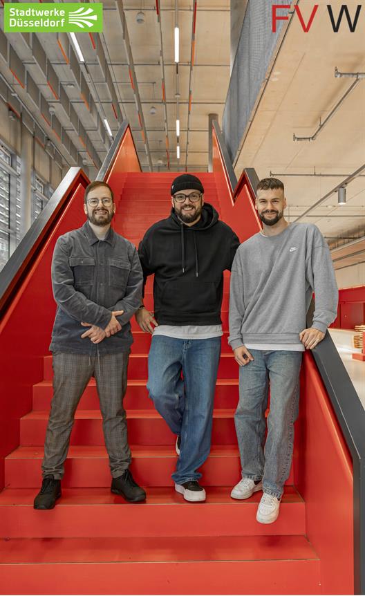 Briefingtermin Stadtwerke Düsseldorf:  Stehend abgebildet auf einer Treppe mit roten Stufen sind Danny Trapp, Lehrbeauftragter an der HSD;
Deniz Sen, Employer Branding Expert der Stadtwerke Düsseldorf und 
Jan Schönfelder, Lehrbeauftragter an der HSD. 